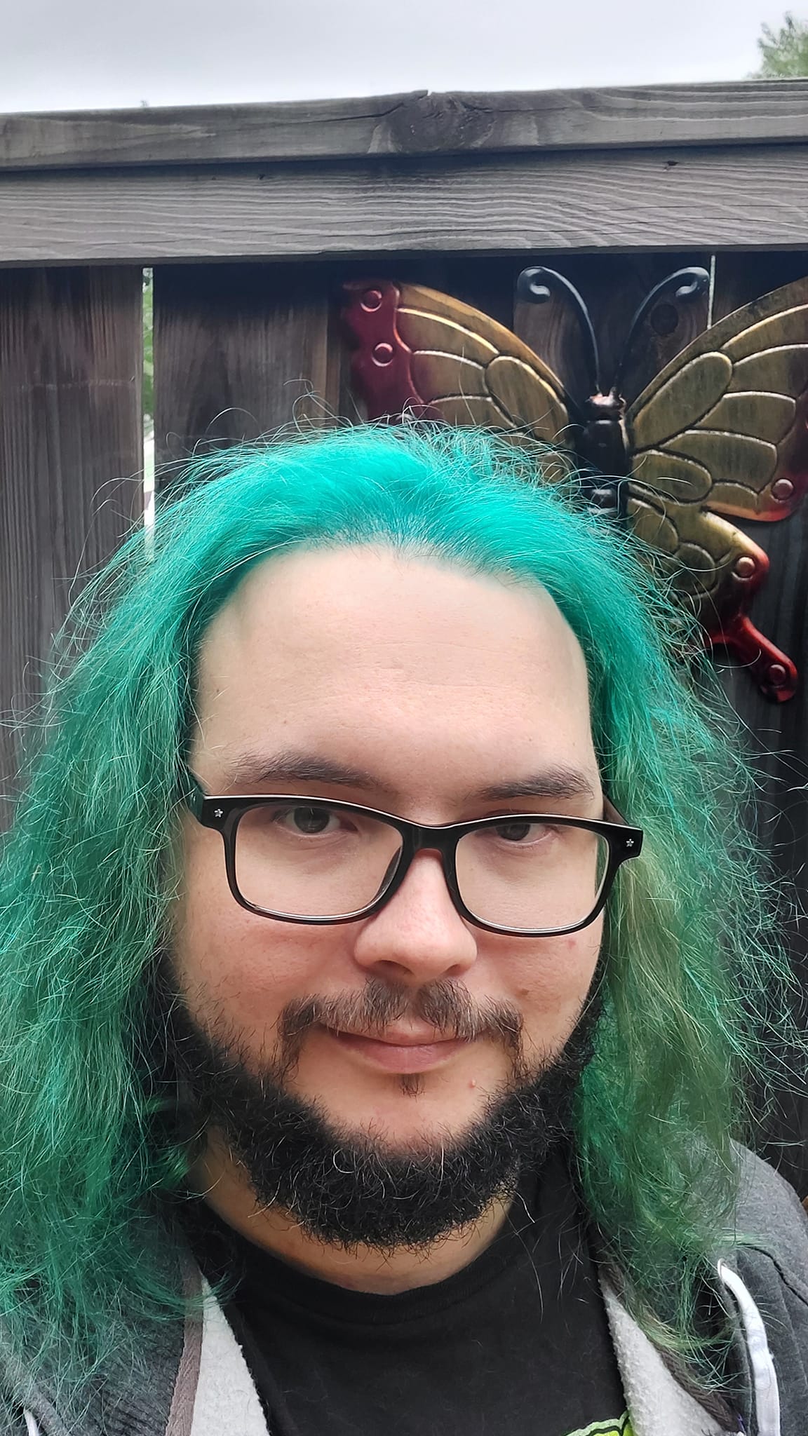 A man with green hair stands outside, photo 1